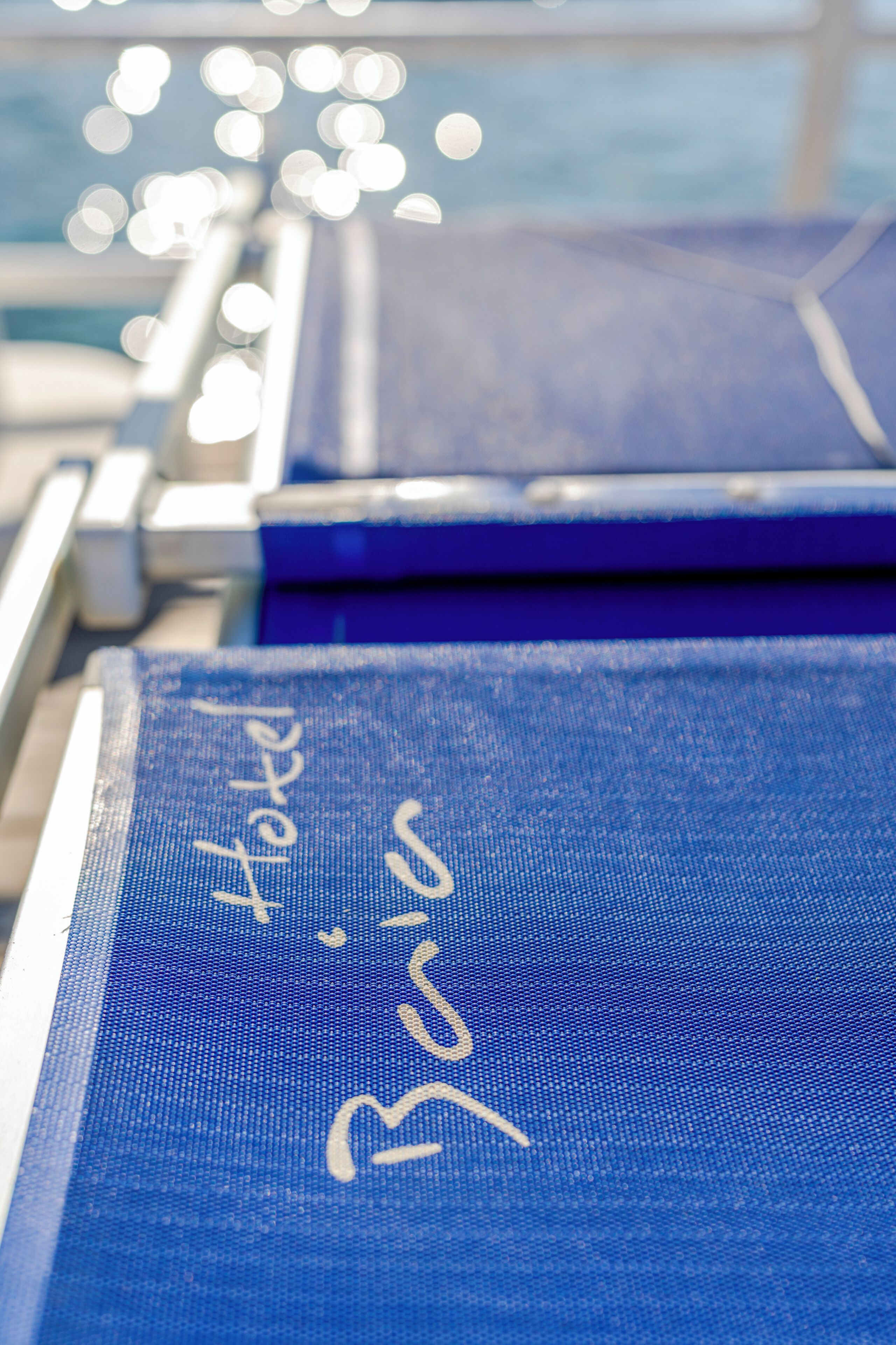 A close-up of a blue fabric with the word 'Hotel' and a partial name.