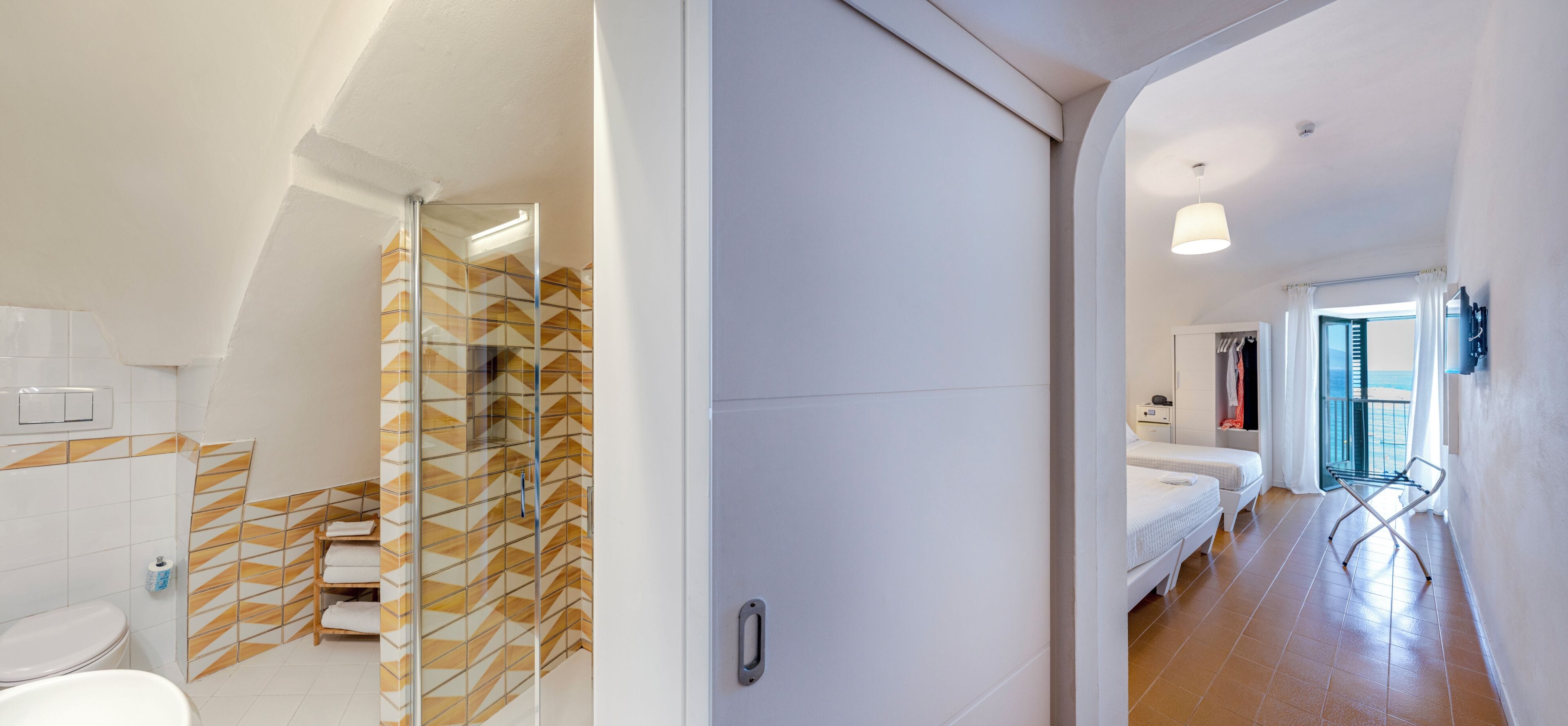A modern bathroom with a shower, a toilet, and a sink.