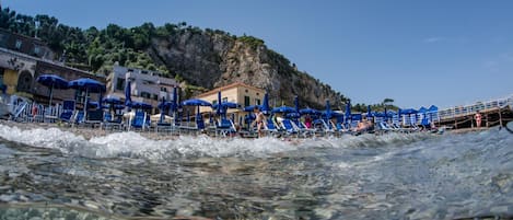 Privat strand i närheten, svart sandstrand, solstolar och parasoller