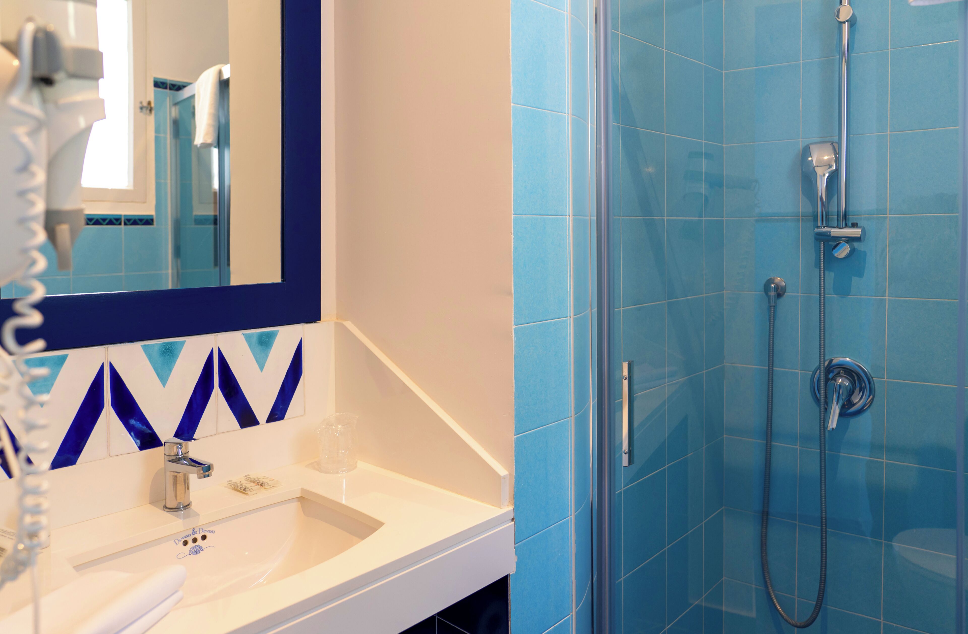 Un baño con lavabo, espejo y ducha.