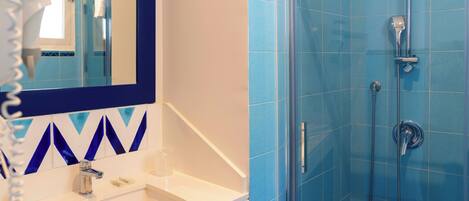 Un baño con lavabo, espejo y ducha.