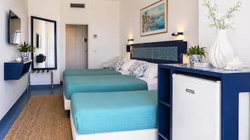 Une chambre avec deux lits, un bureau, un réfrigérateur, un miroir et un tableau au mur.