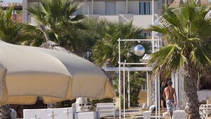 Um hotel chamado "DU SOLEIL", com design arquitetônico moderno, apresentando varandas e um terraço no último andar.