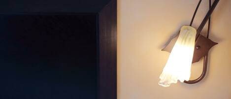 Una lámpara de pared con un diseño peculiar, posiblemente un aplique, sobre una pared lisa.