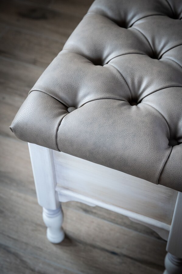 A tufted chair with a cushioned seat and backrest.