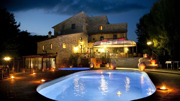 A stone building with a swimming pool at dusk. - Il Castelluccio Country Resort (Barberino di Mugello)