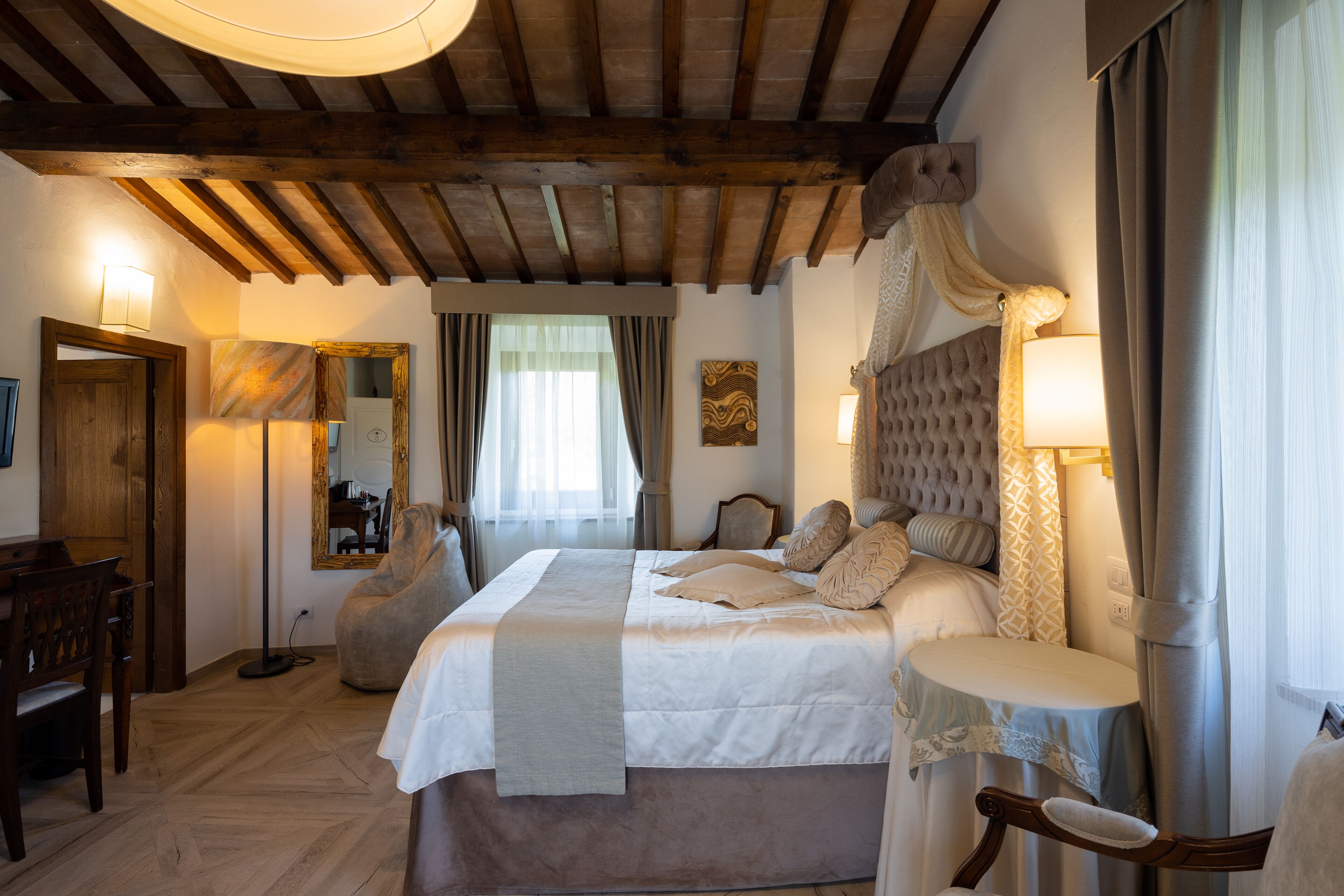 Un dormitorio con una cama grande, techo de madera, un escritorio y una silla.