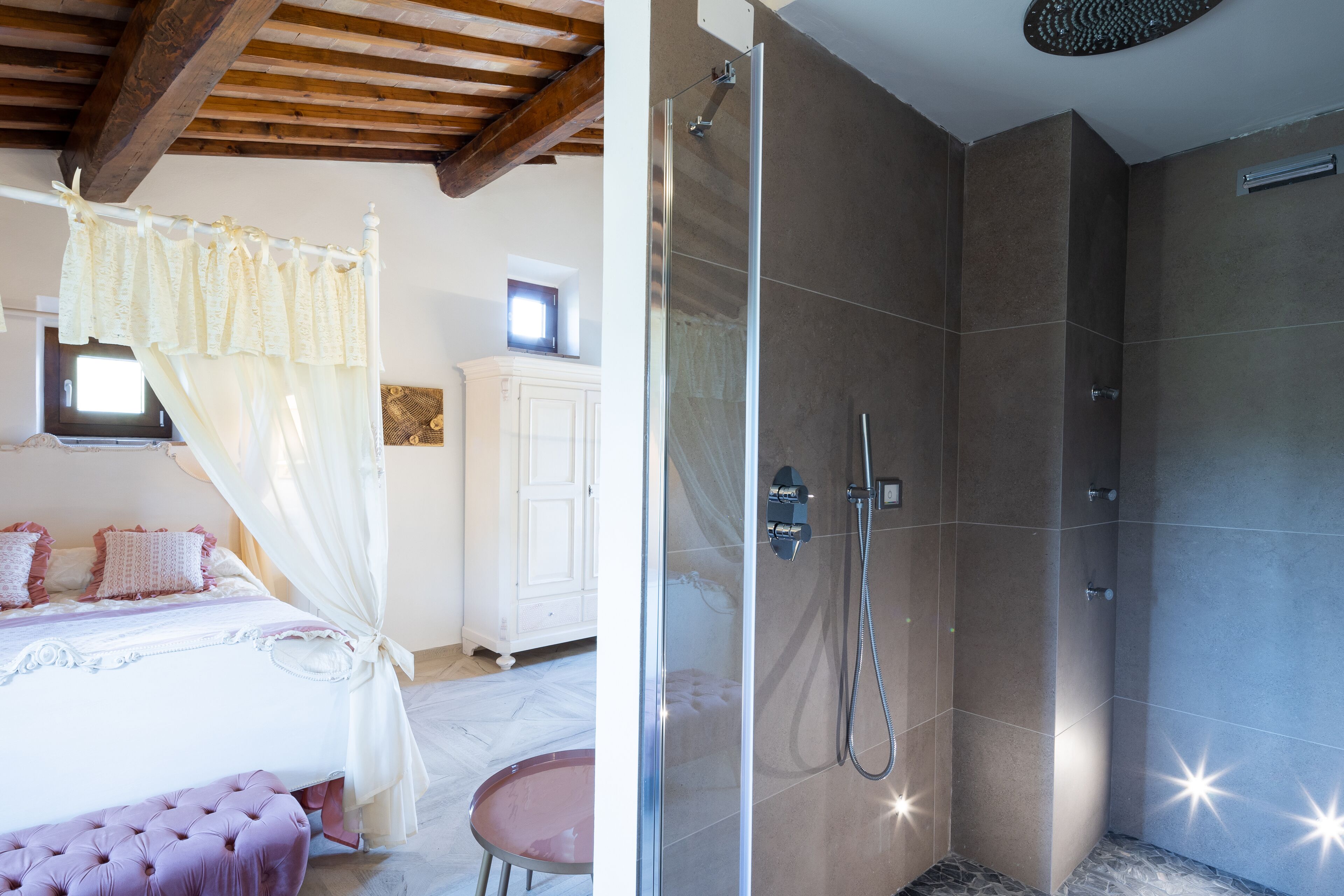 Un dormitorio con cama a dosel y zona de ducha independiente con paredes de azulejos.