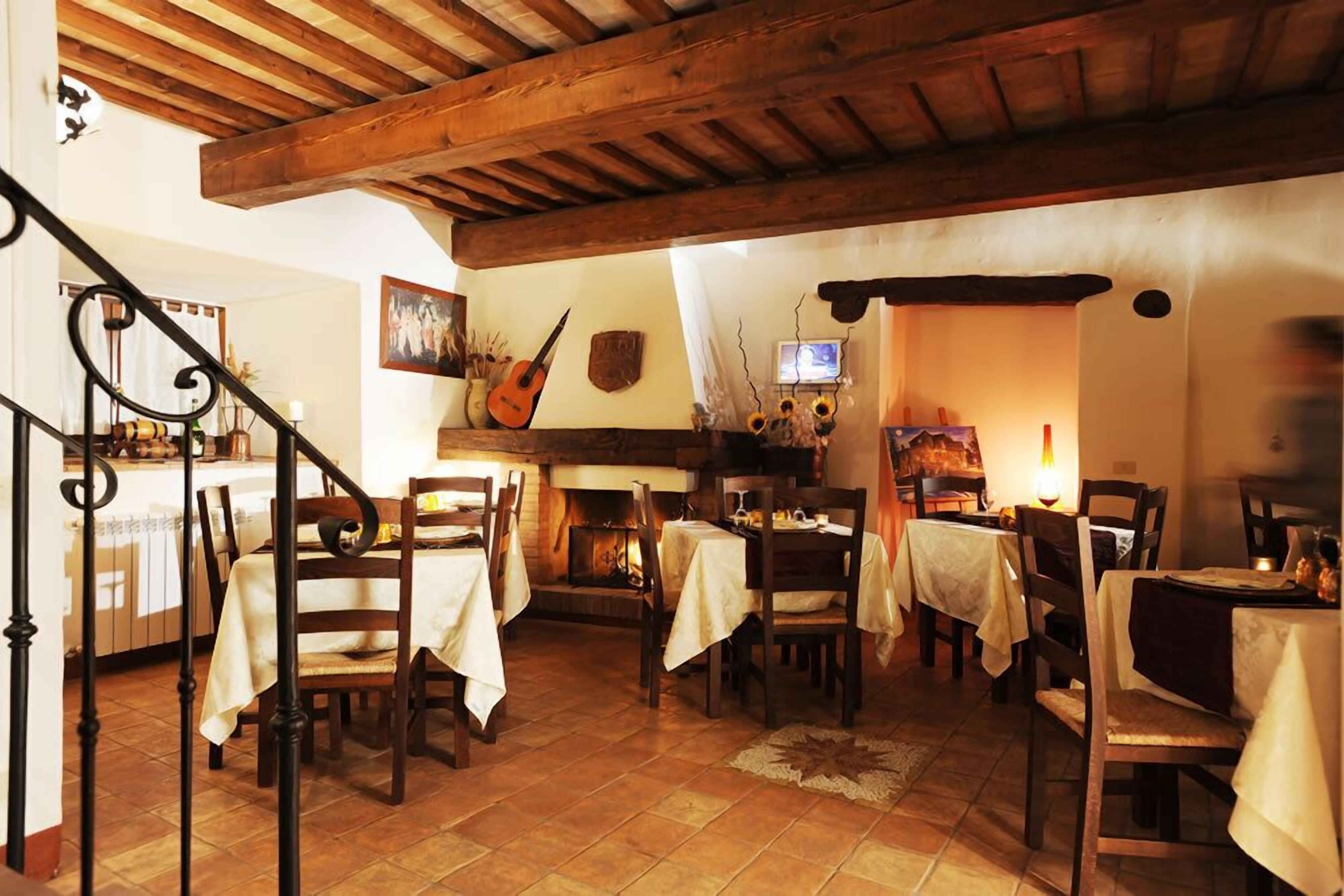 A cozy dining area with wooden beams, tiled flooring, and tables set for dining.