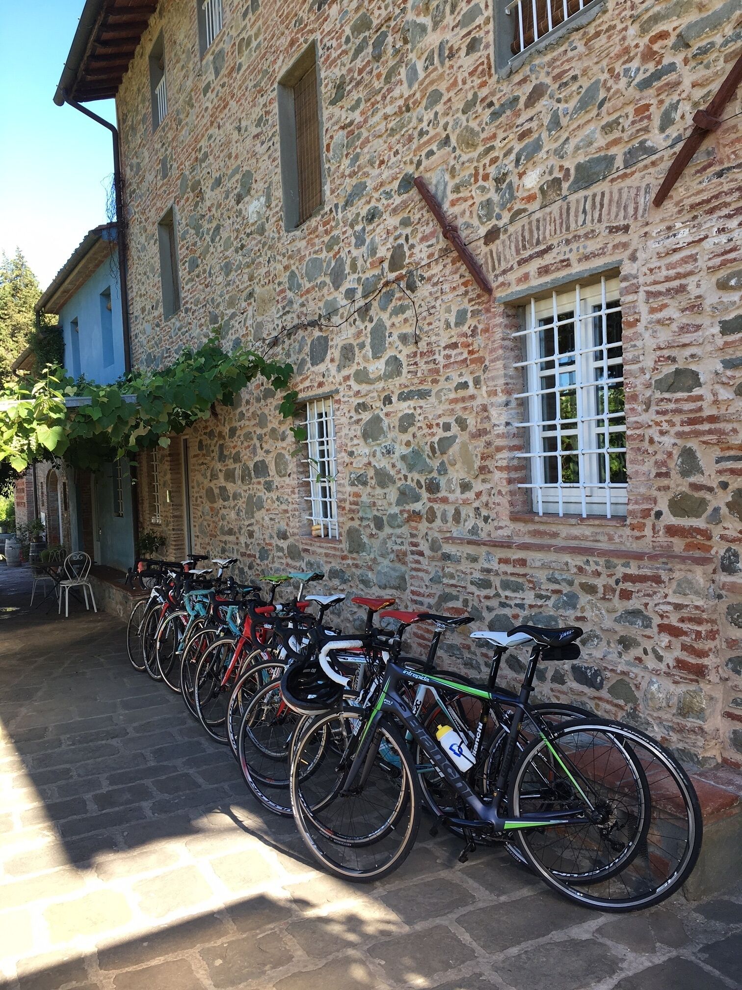 A row of bicycles parked against a stone building with a rustic appearance.