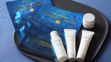 A tray with a blue package labeled 'ESSENCE MASK' and three tubes of 'MOONPEARL' skincare products.