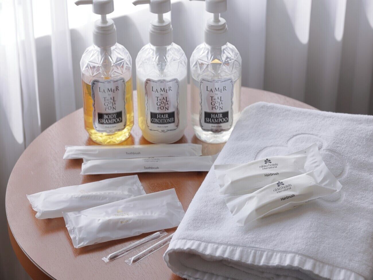 Een tafel met toiletartikelen, zoals shampoo, conditioner en haarborstels, en een handdoek.