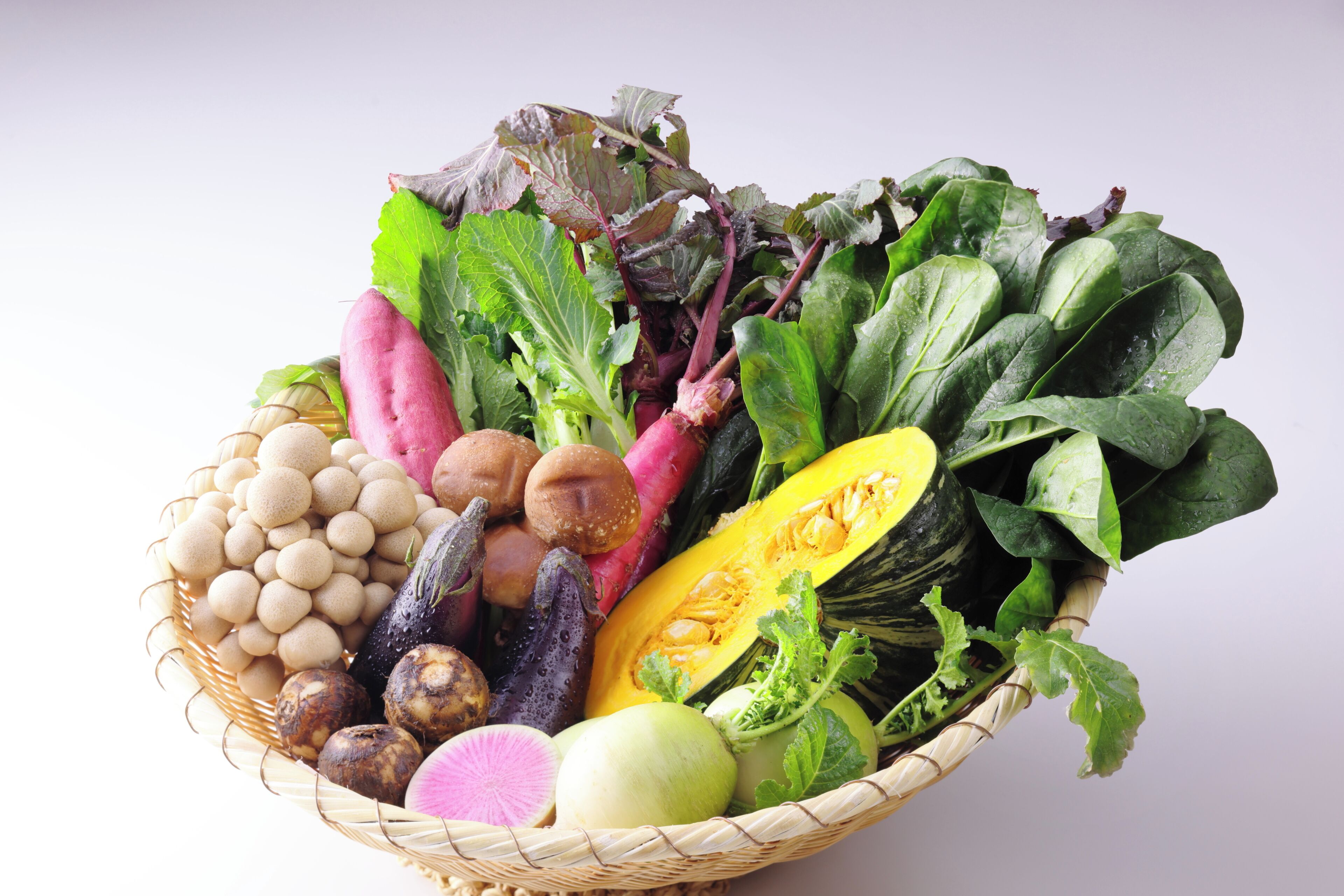 A basket filled with various vegetables and fruits.
