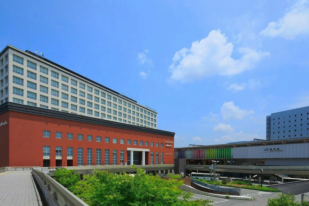 A multi-story building with a red facade and a flat roof.
