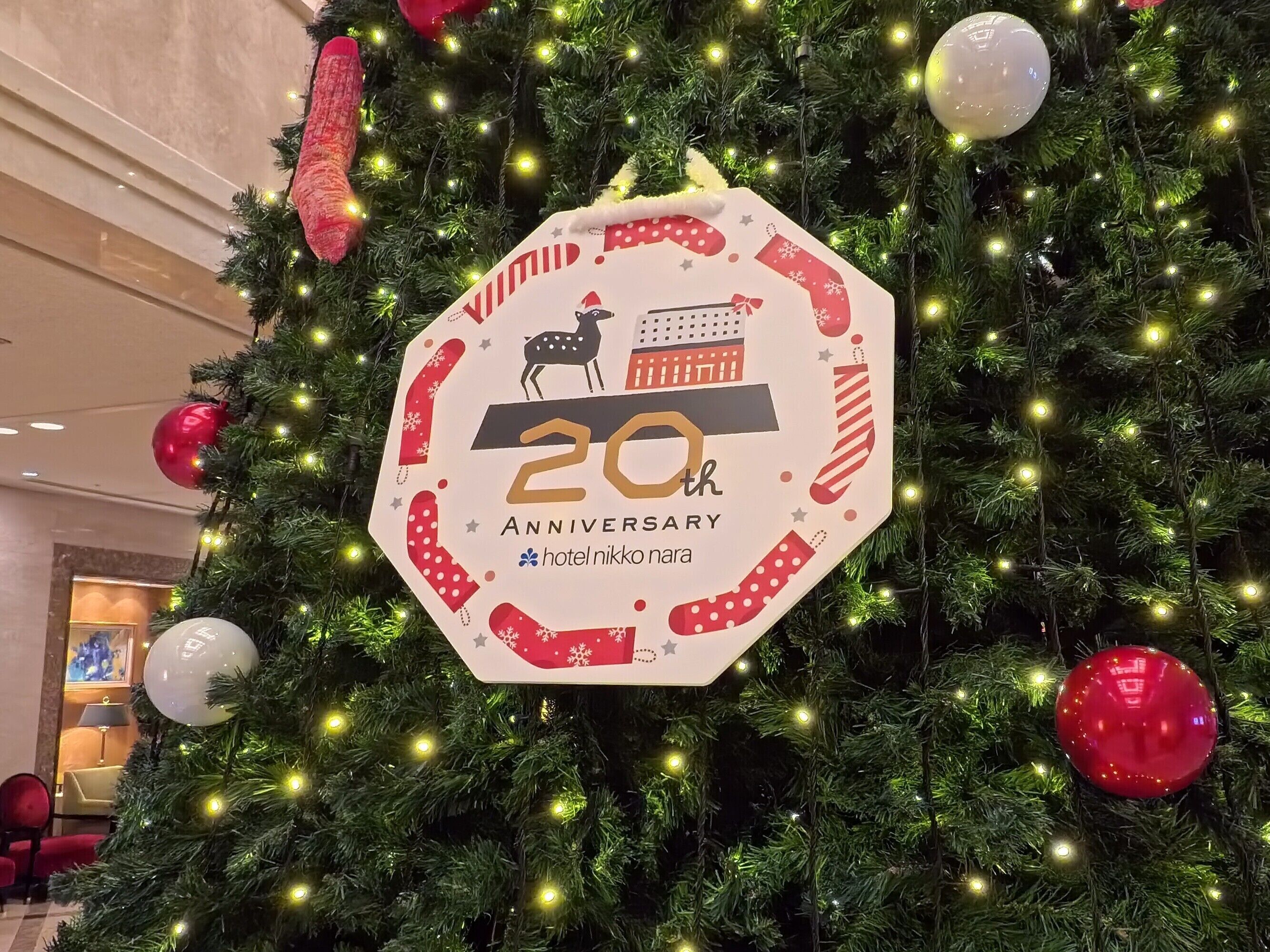 A Christmas tree with a sign indicating a 20th anniversary.