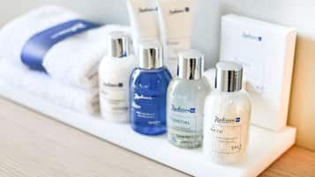 A selection of Radisson hotel bath products including shampoo, body wash, and salt on a white shelf.