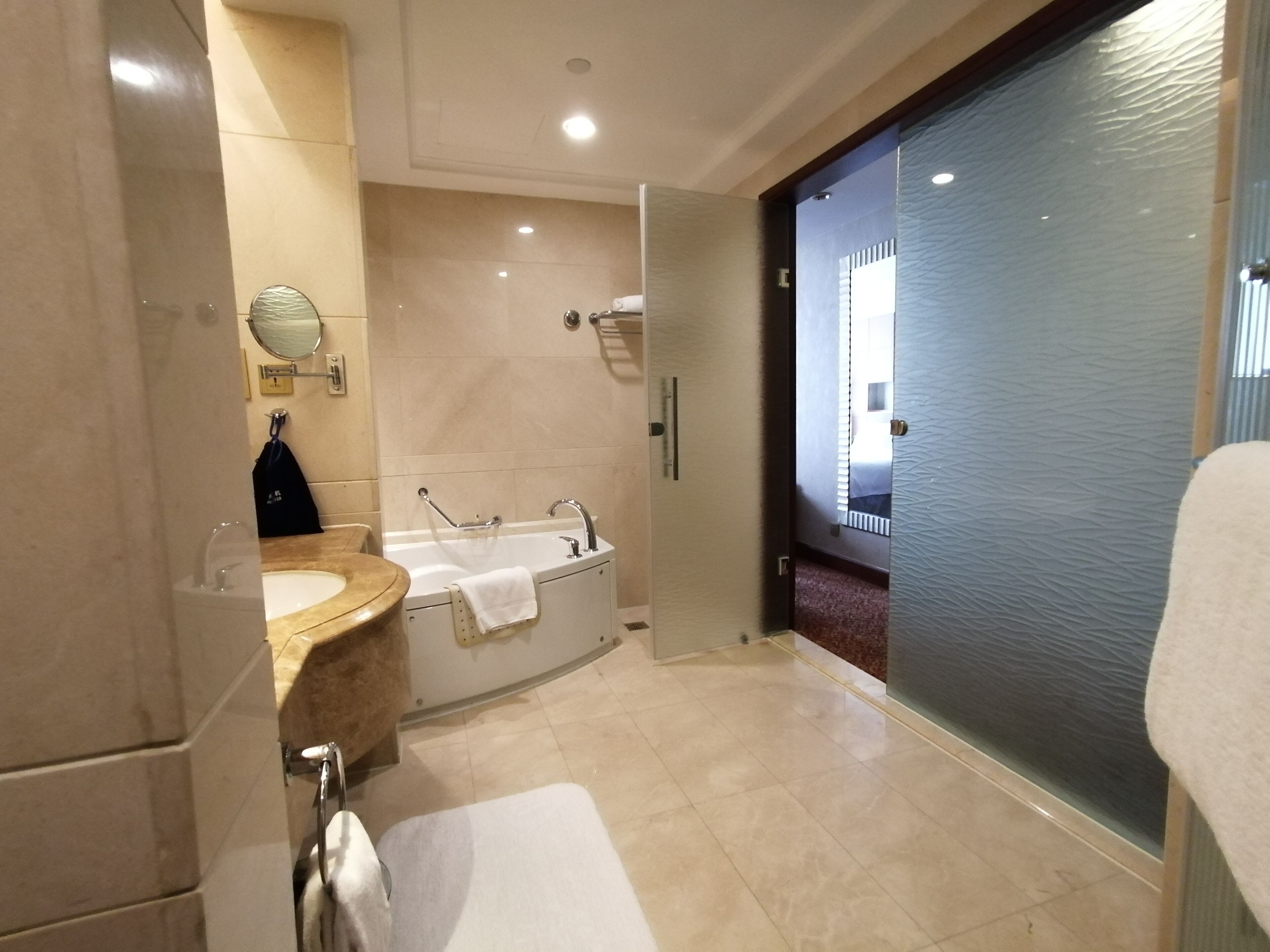 A modern bathroom with a bathtub, a sink, and a glass shower enclosure.