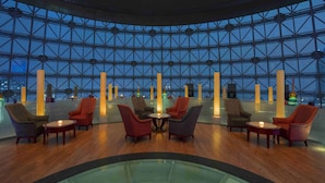 A modern lounge with a geometric glass ceiling, wooden flooring, and multiple seating areas with tables. - Radisson Blu Hotel Shanghai New World (Shanghai)