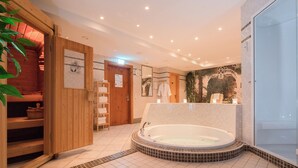 Une salle de spa moderne avec une grande baignoire, des étagères en bois et un sol carrelé.