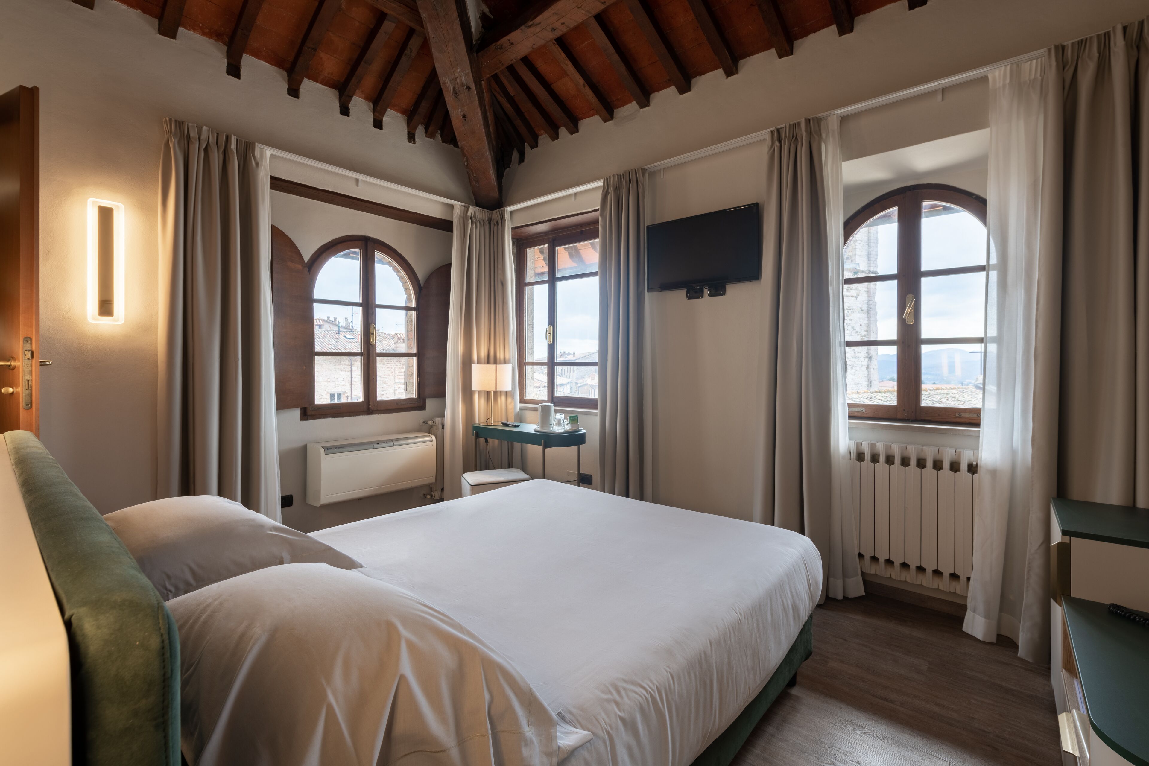 deluxe room, city view, corner | down duvets, minibar, in-room safe, desk