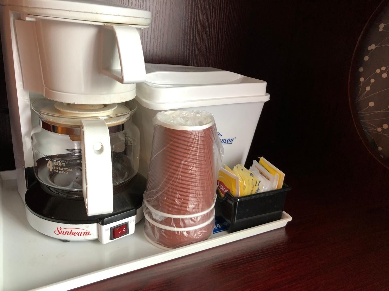 A Sunbeam coffee maker with a water reservoir, a drip coffee filter, and a coffee pot.