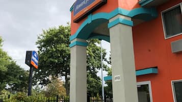 La entrada al hotel Howard Johnson, con un cartel sobre la entrada y un letrero que indica la ubicación de la oficina.