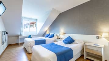 Habitación de hotel moderna con dos camas, un escritorio y una ventana.