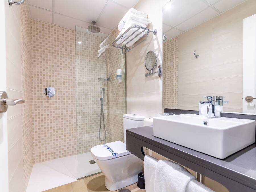 A modern bathroom with a shower, toilet, and sink.