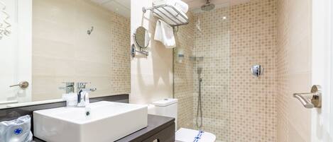 A modern bathroom with a white sink, a toilet, and a shower area.