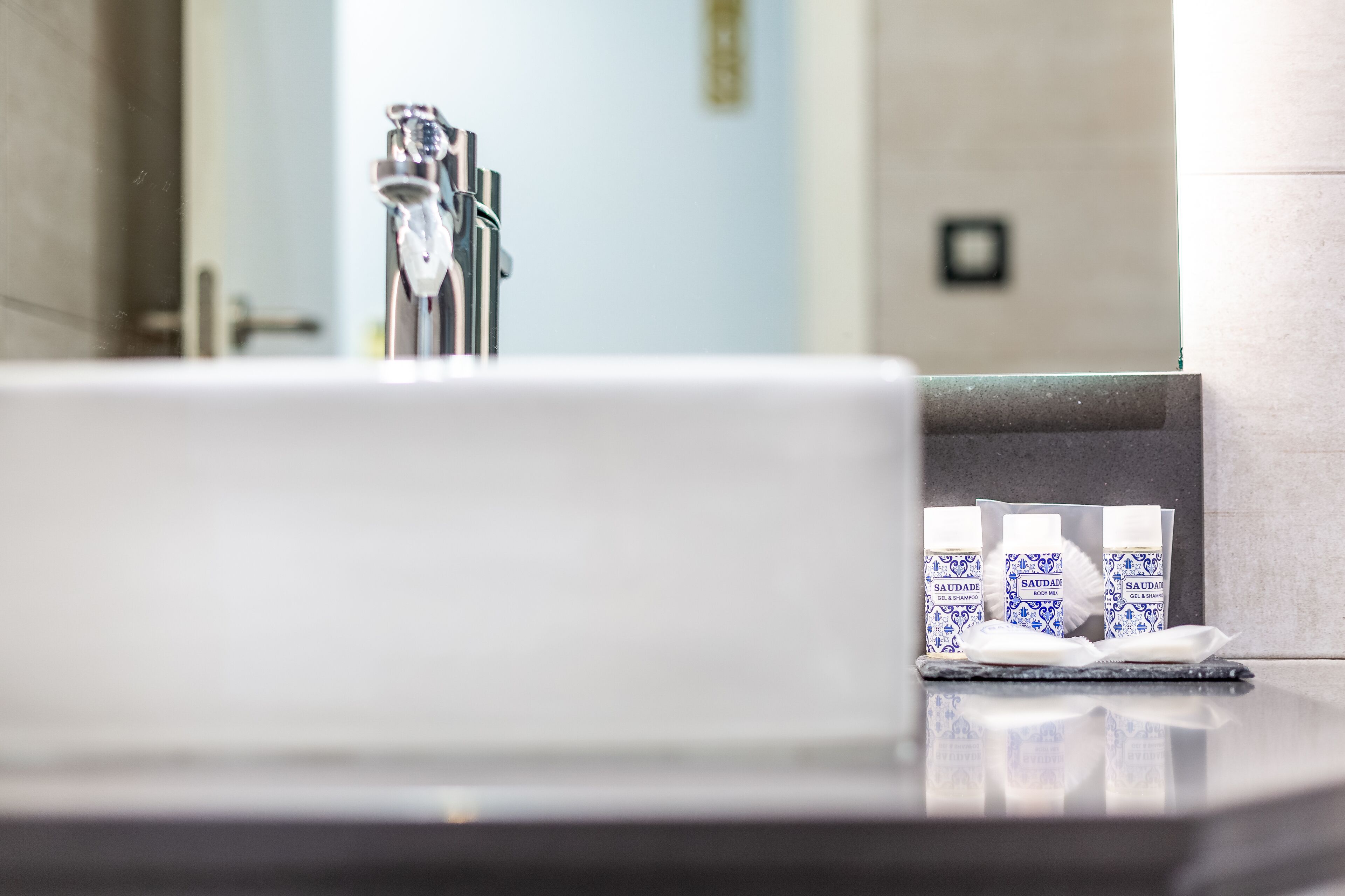A bathroom sink with a mirror, a faucet, and a tissue box.