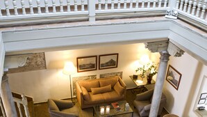 A spacious indoor courtyard with a seating area, stone flooring, and potted plants. - Hotel Palacio de Los Navas (Granada)