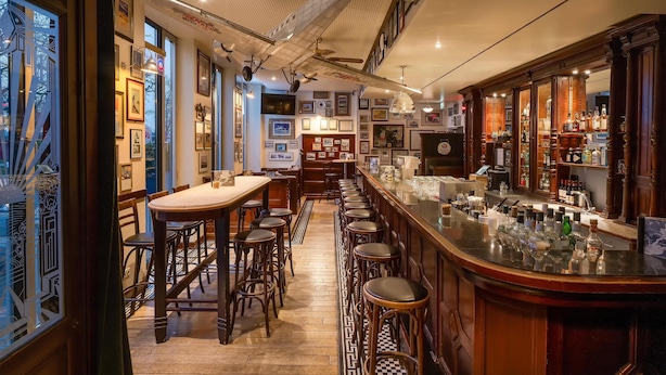 A bar area with stools, a counter with bottles, framed pictures on the walls, and a patterned floor. -  IntercityHotel Frankfurt Airport Terminal 3 (Frankfurt)