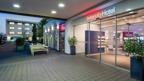 A hotel entrance with a modern design, glass doors, and a sign reading 'Intercity Hotel.' -  IntercityHotel Frankfurt Airport Terminal 3 (Frankfurt)