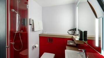 Ein modernes Badezimmer mit Dusche, Toilette, Waschbecken und Spiegel.