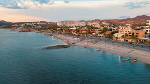 A coastal town with a beachfront, boats, and buildings. - Posada De Las Flores La Paz (La Paz)