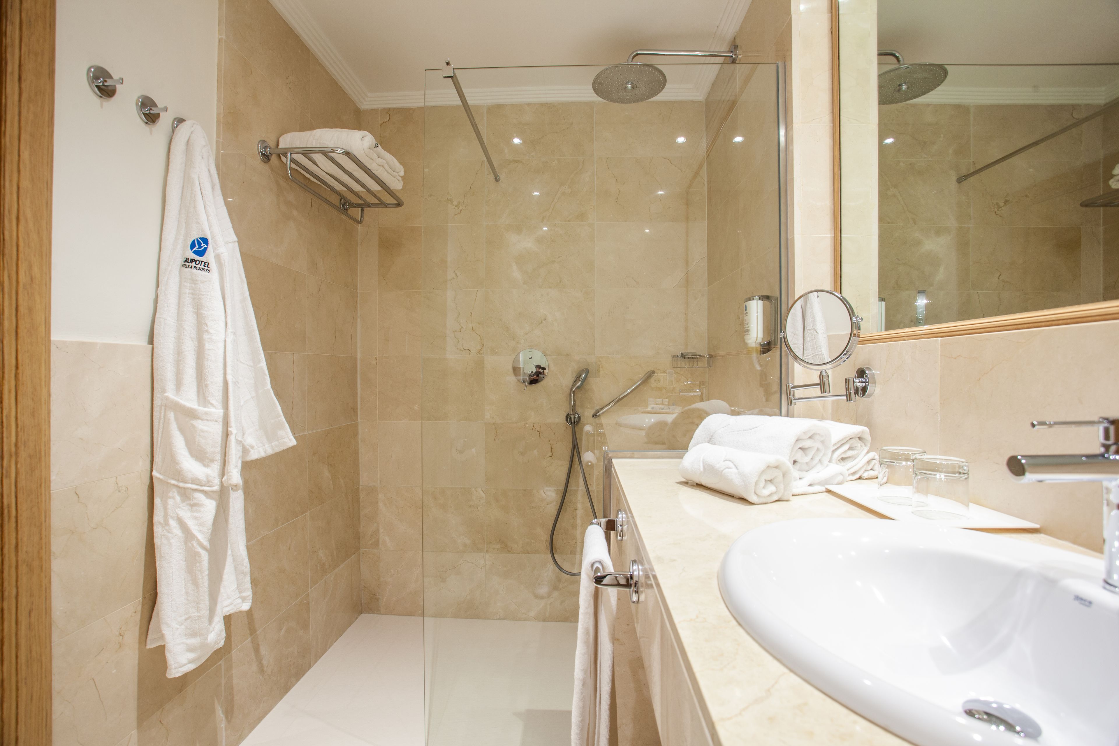 A modern bathroom with a glass-enclosed shower, a large sink, and a mirror.