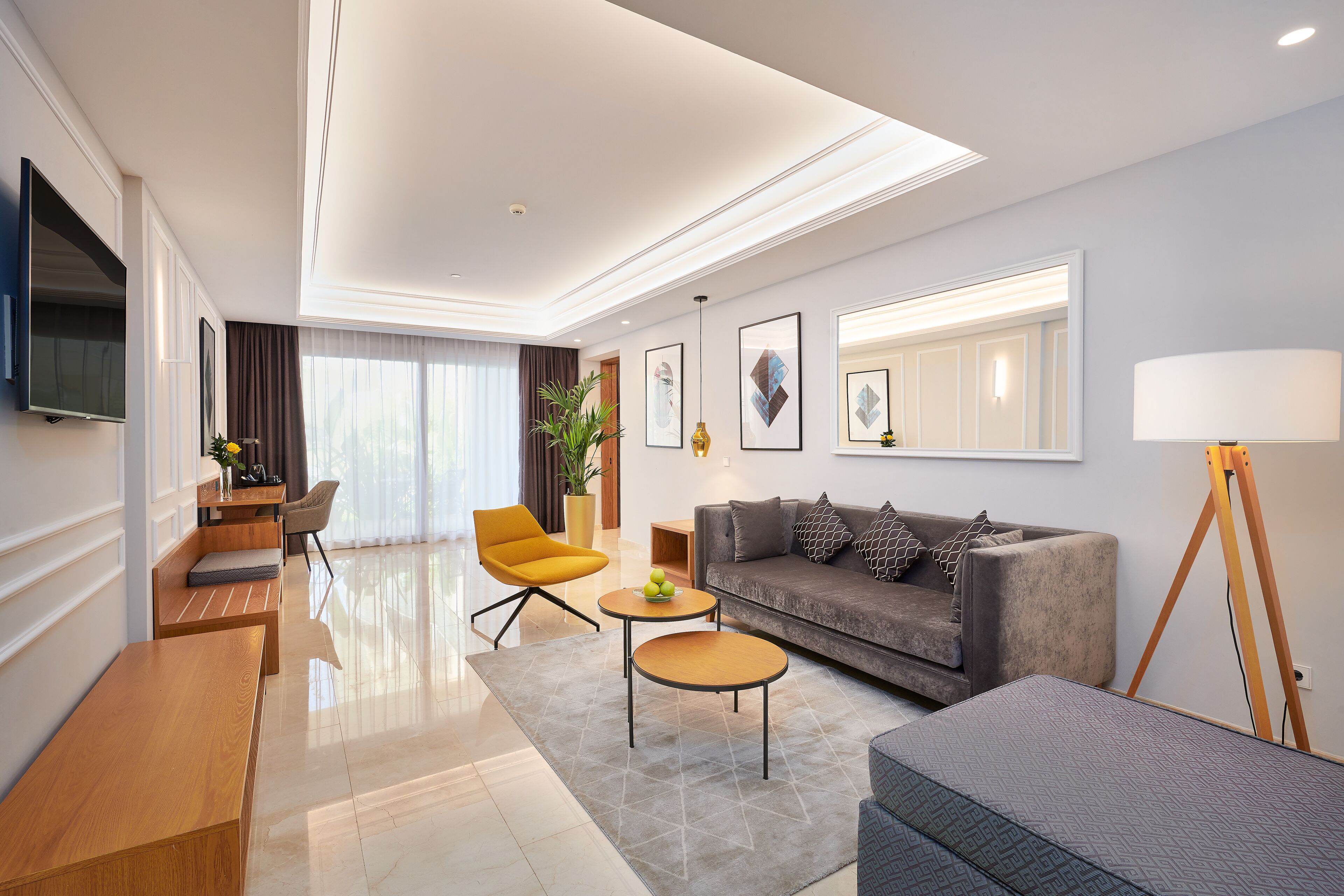 A modern living room with a sofa, coffee table, and a TV mounted on the wall.