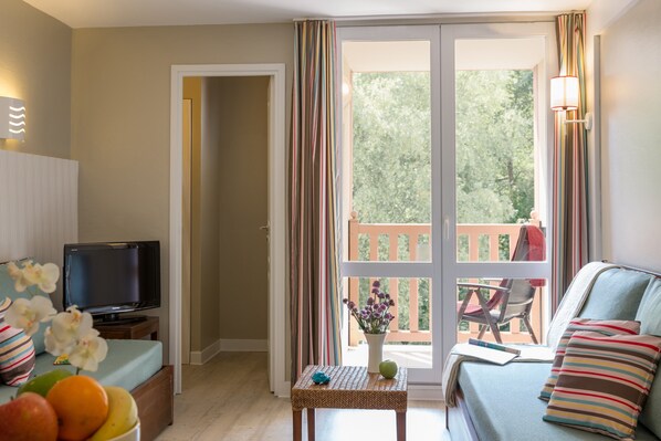 Appartement 6 personnes - 1 chambre + 1 coin nuit - Terrasse ou balcon | Salle de séjour | Téléviseur à écran plat, livres