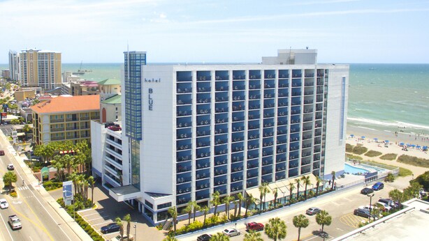 Ett hotell med många balkonger med utsikt över stranden.