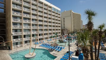 A hotel with multiple floors, a swimming pool, and sun loungers.