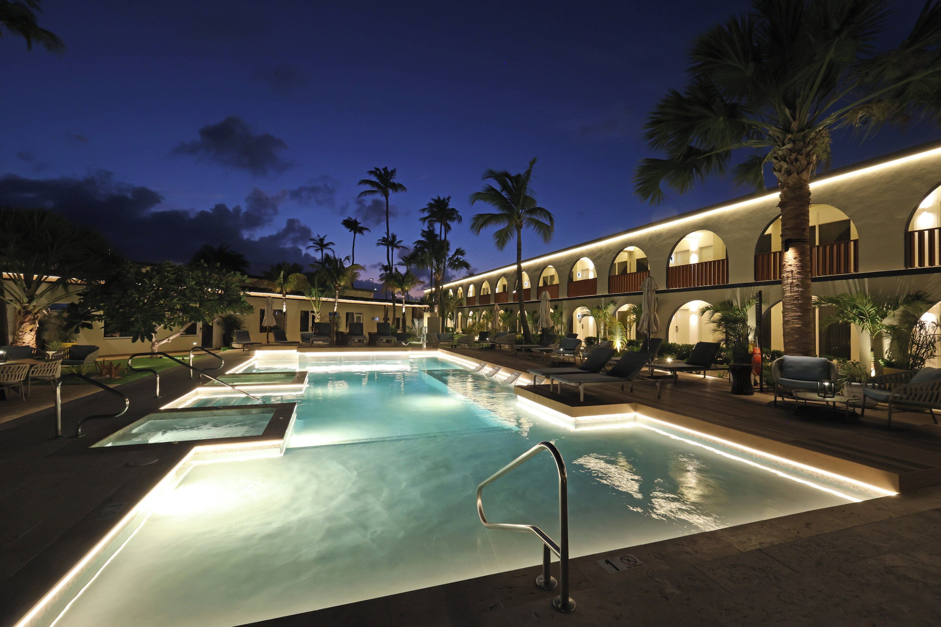 Una piscina al aire libre, sillones reclinables de piscina