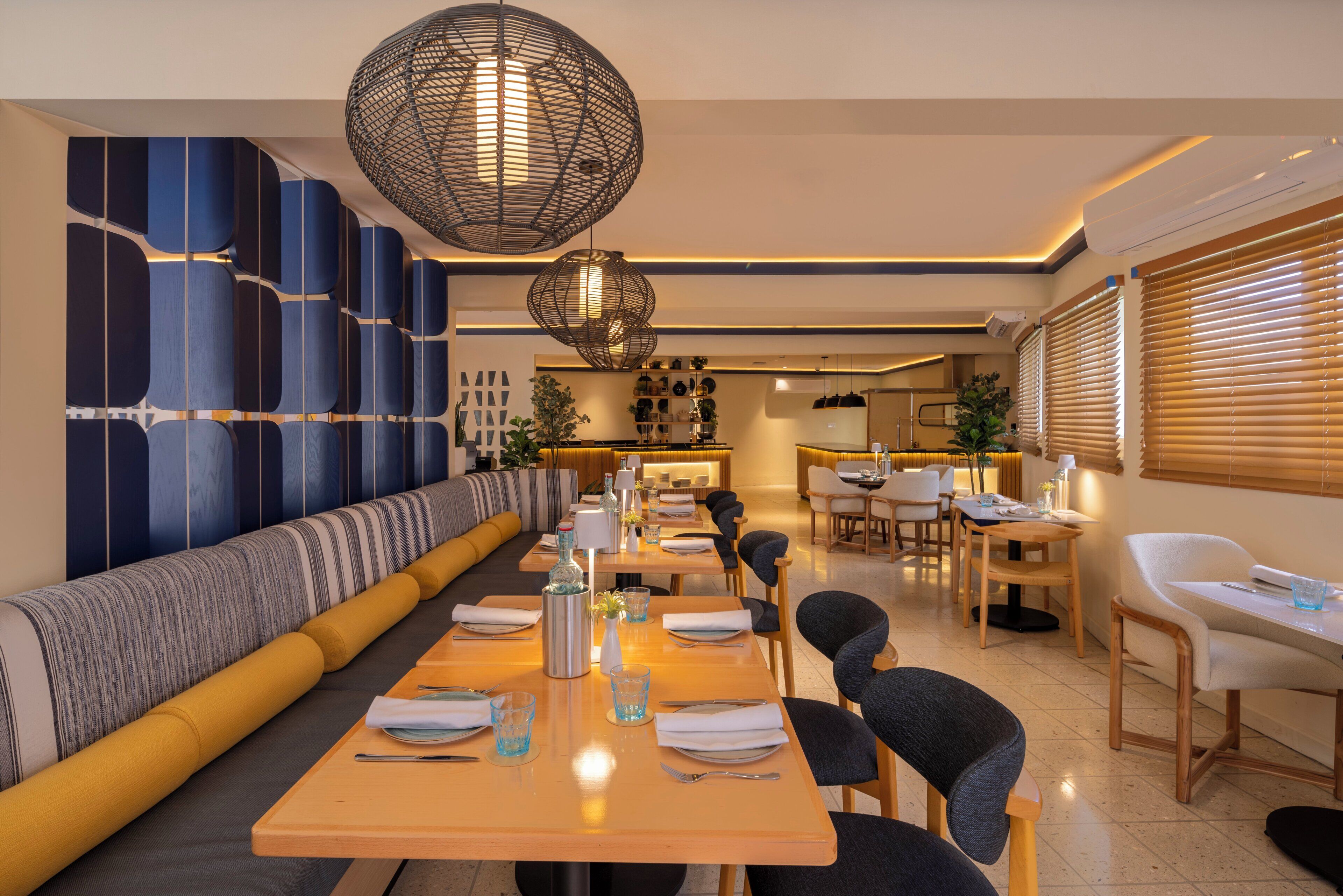 Uma área de jantar moderna com uma mesa comprida, cadeiras e parede com padrão.