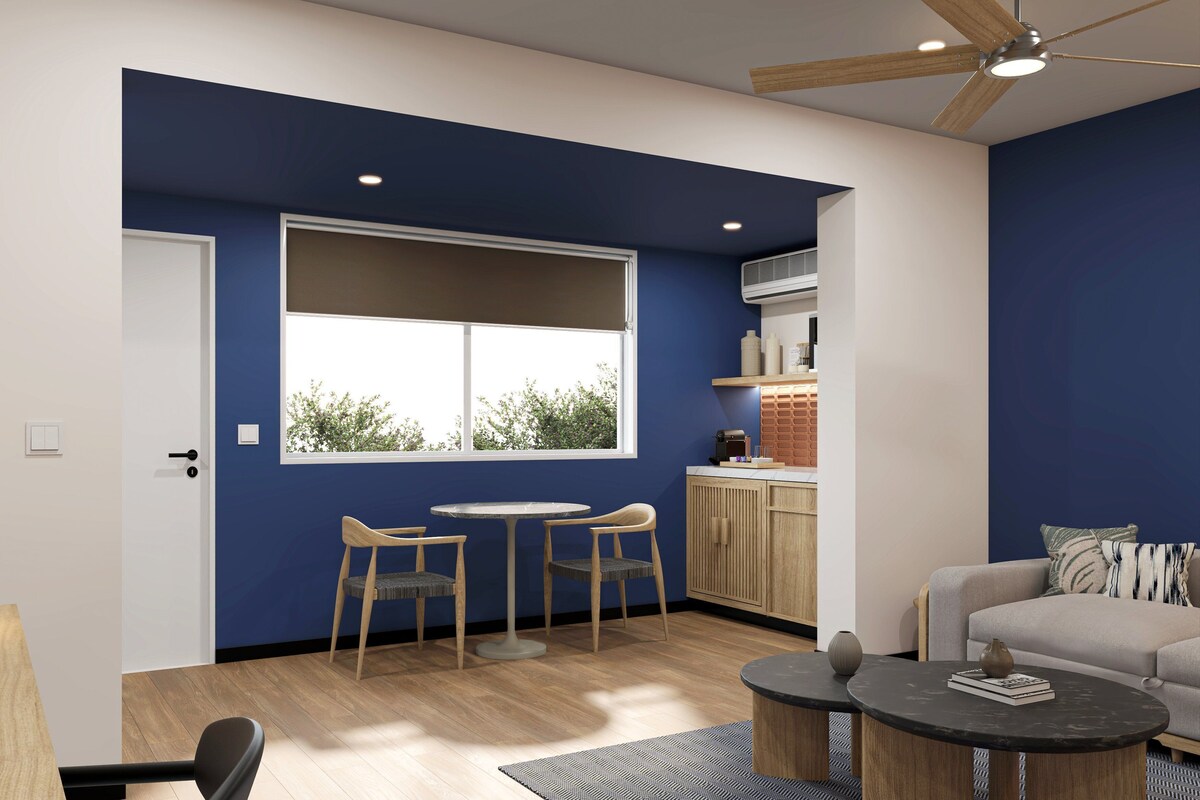 Una sala de estar moderna con comedor, cocina y un ventanal grande.