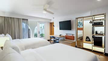 A hotel room with two beds, a desk, a chair, a TV, and a wardrobe.