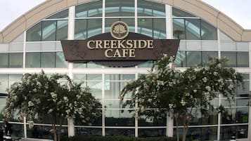 Un edificio con un letrero que dice "Creekside Cafe" y un amplio escaparate de vidrio.