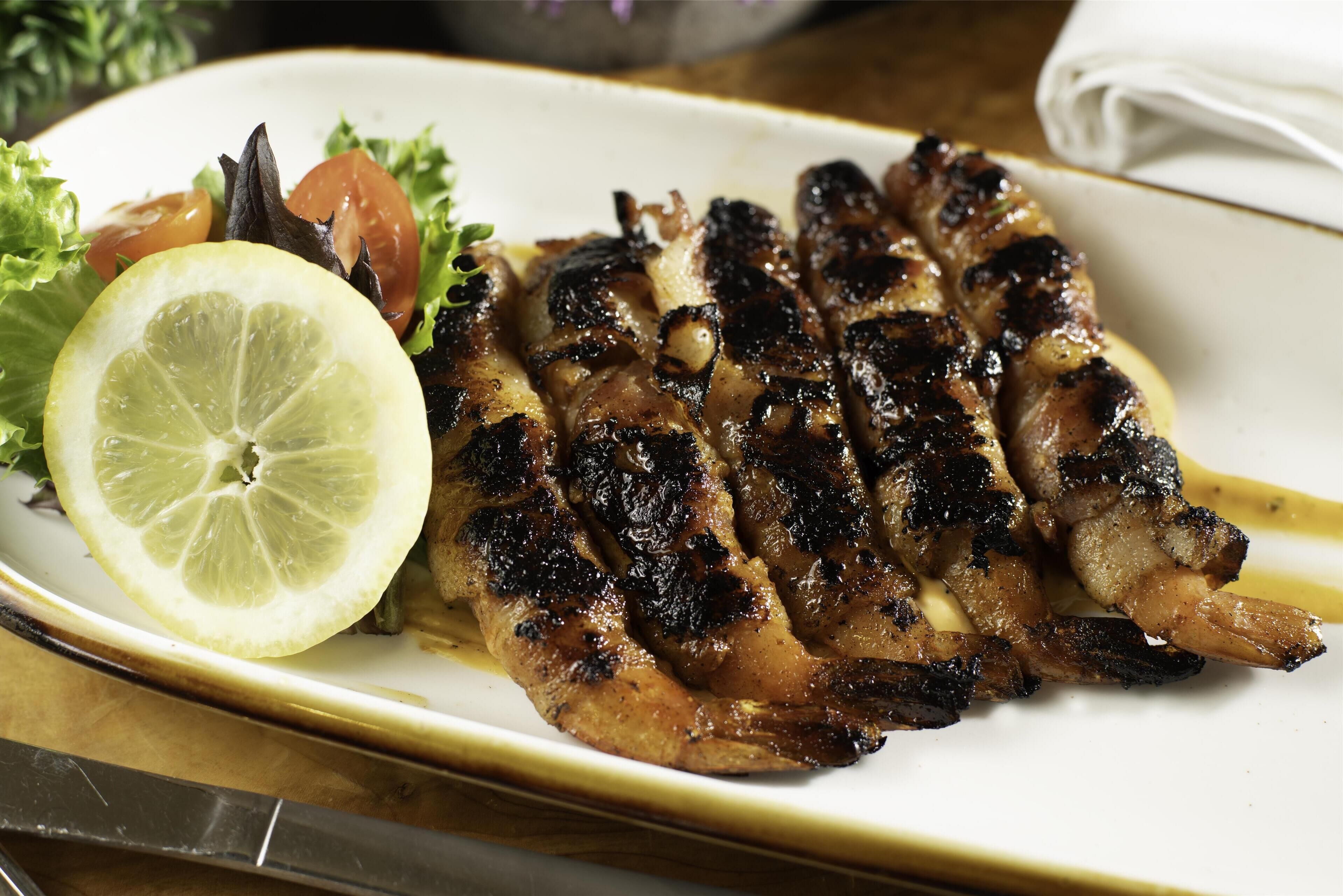 A plate with grilled chicken, a slice of lemon, and a side salad.