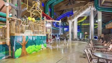 A spacious indoor area with a water feature, seating arrangements, and a mural of a tree.