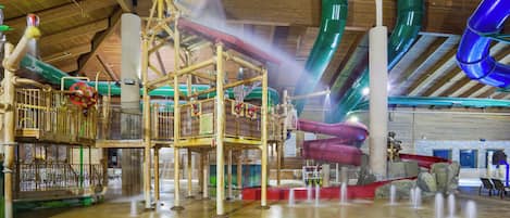 Een overdekt waterpark met glijbanen en waterattracties.