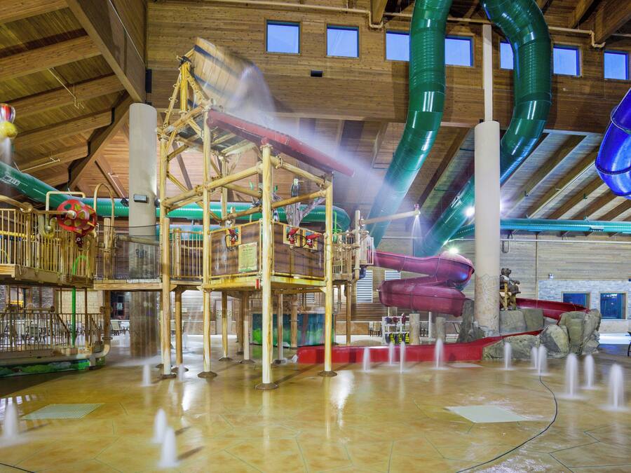 Parque acuático interior con múltiples toboganes y atracciones acuáticas.