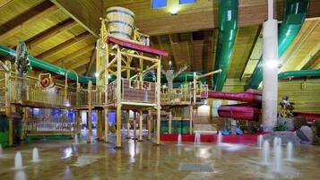 An indoor water park with wooden structures, slides, and a high ceiling.